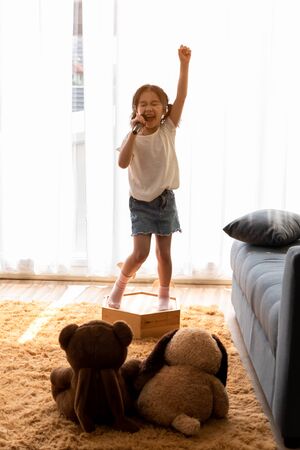 Cute little girl dream of being a super star performing concert for her pet and friend dollsの写真素材