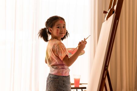 Young little girl painting on a large canvas, kid's dream of being an artistの写真素材