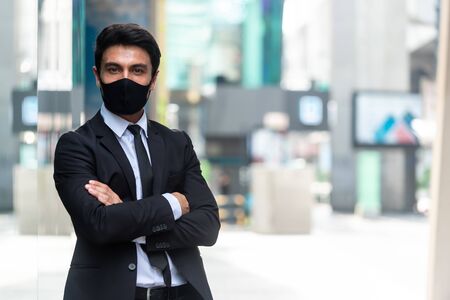Portrait of businessman wearing suit and mask show new normal life style after covid crisisの写真素材