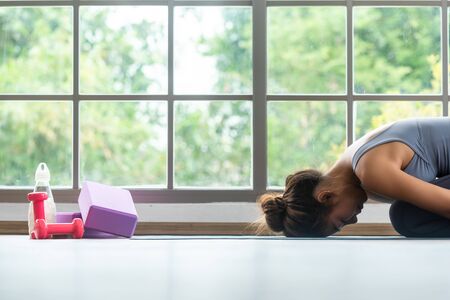 Close up of woman performing yoga child pose with equipment for practice yogaの写真素材