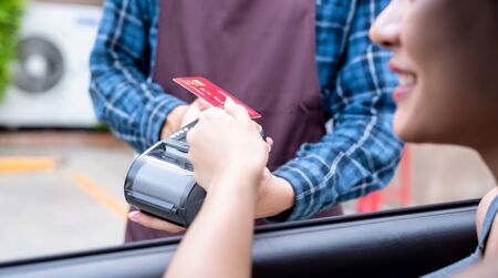 Woman drive thru shopping use credit card to pay without cashの写真素材