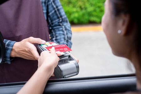 Woman drive thru shopping use credit card to pay without cashの写真素材