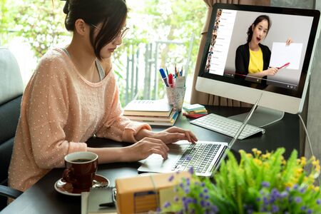 Online course attended by woman at home and working at the same time, learning at home with 10 other peopleの写真素材
