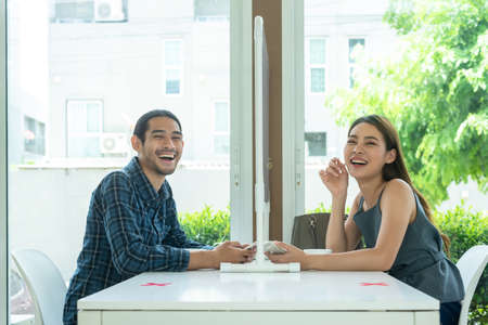 Two customer sit in restaurant with screen separate from each other prevent germs spreadの写真素材