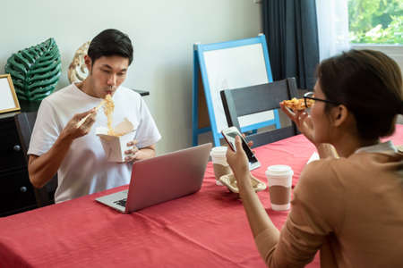 Asian couple having lunch at home by order delivery foodの写真素材