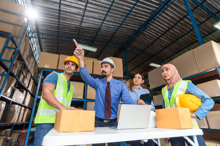 Warehouse management team working together in a large warehouseの写真素材