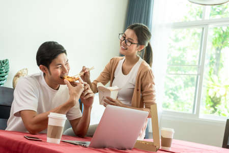 Asian couple having lunch at home by order delivery foodの写真素材