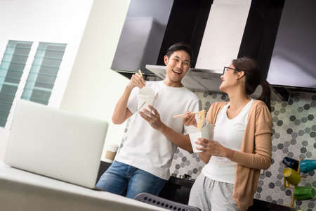 Asian couple having lunch at home by order delivery foodの写真素材