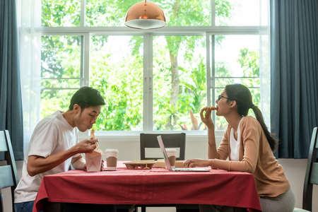 Asian couple having lunch at home by order delivery foodの写真素材