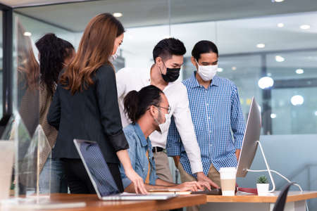 Five office worker have a small meeting brainstorm together with everyone wear mask as new normal lifestyleの写真素材