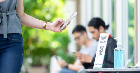 Woman customer entering a shop use smartphone scan qr code before step inの写真素材