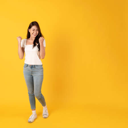 Smiling asian woman white shirt on yellow background with happy feeling show appreciation