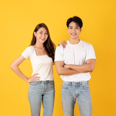 Couple of teenage asian boy and girl together isolate on yellow backgroundの写真素材