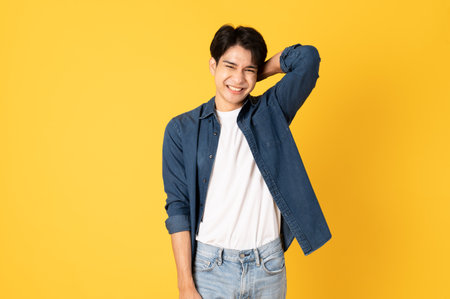Smile happy asian man wearing shirt with jeans and laughing isolated on yellow backgroundの写真素材