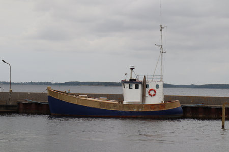 Old fishing boat laying at the dock in small harbor
