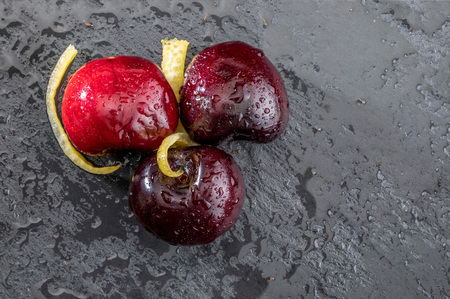 Precious red and fresh cherry pints, fresh and raw on a textured and veined black background. With...