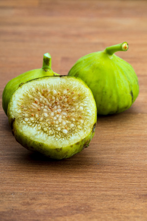 Green figs, fresh and ripe. With a fig leaf Wood background.