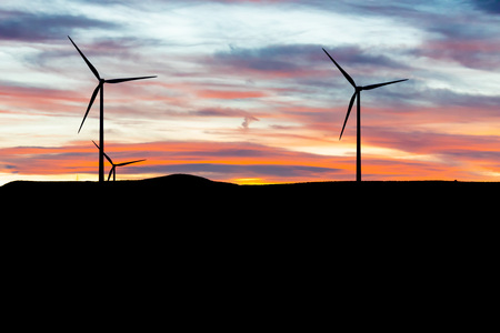 Electric wind turbines, backlighting in beautiful sunset (sunny)の写真素材