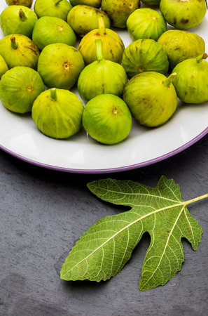 Green figs, fresh and ripe. With a fig leaf Wood background.の写真素材