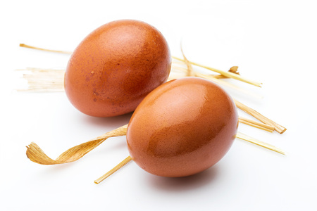 Two raw and fresh eggs with straw. Isolated on white background.の写真素材