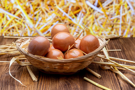 Fresh and raw eggs in wicker basket and straw. Rustic and granaja image.の写真素材