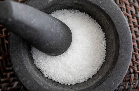 Close-up with fat salt. In stone mortar. Rustic appearance.