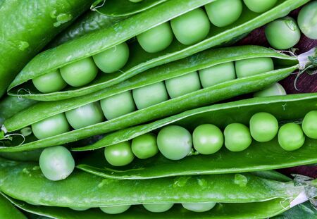 Green, tender, fresh and raw peas. Close-up and top view. Rustic appearance.の写真素材