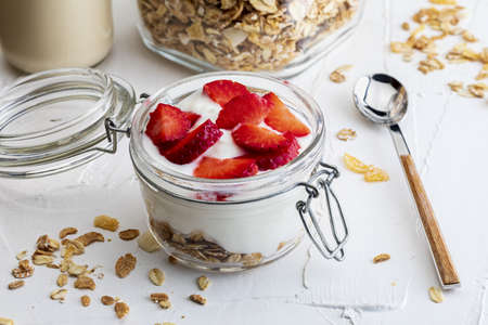 Delicious dessert of strawberries, yogurt and sugar-free cereals. On white background.の写真素材