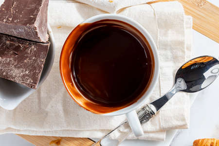 Appetizing breakfast with a delicious cup of thick, drinkable hot chocolate, along with chocolate bars. Bolw half full, half empty. Top view. Homemade look.の写真素材