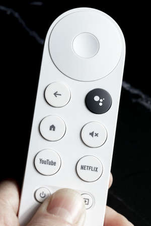 SPAIN - March 3, 2021. Close-up of the remote control for Chromecast with Google TV in one handのeditorial素材