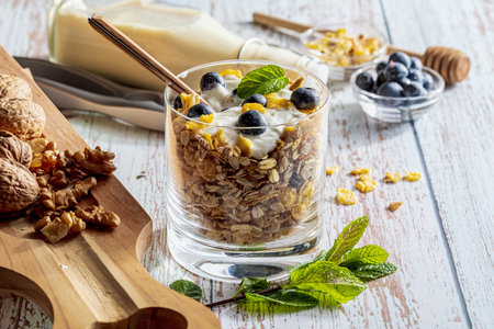 Delicious dessert of blueberries, yogurt and cereals (muesli). Refreshing and healthy breakfast of yogurt, blueberries, dried fruits and dried fruits. With copy space.の写真素材