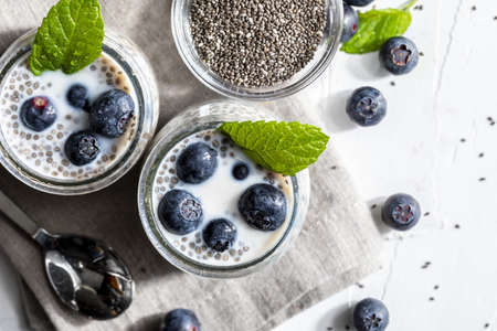 Appetizing, healthy and refreshing chia seed pudding with fresh blueberries and mint leaves. Vegetarian and vegan food with healthy superfoods. Homemade look. Top view with copy space.の写真素材