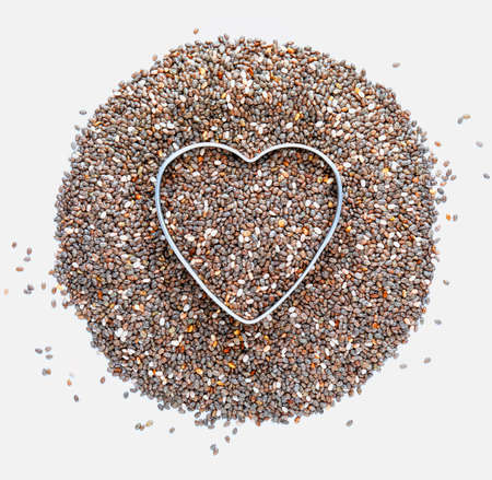 Heap of chia seeds with a heart. Love for chia. Isolated on white background. Macro close-up. With copy space.の写真素材