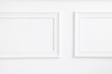 Beautiful ornate white decorative plaster mouldings in studio. The white wall is decorated with exquisite elements of plaster stuccoの写真素材
