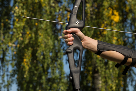 The man shoots from the bow. Close-up. Practice of archery