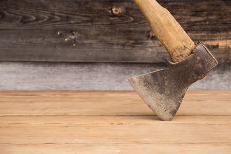 Old ax with a wooden handle stuck in wooden log. Concept for woodworking or deforestation. Selective focus.の写真素材