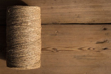 A roll of twine on a wooden background. Selelective focus. Close-up. Free space for text.
