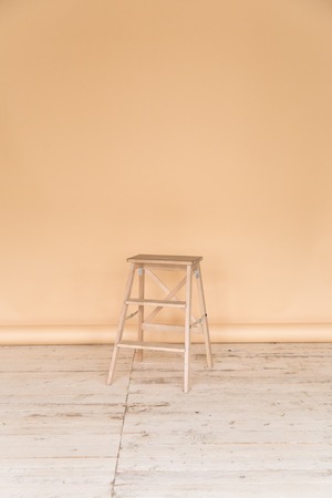 The working space of the photo studio with a beige paper background and chair.の写真素材