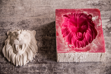 Plaster workshop. Separates the silicone mold from the plaster sculpture of the lions head.の写真素材