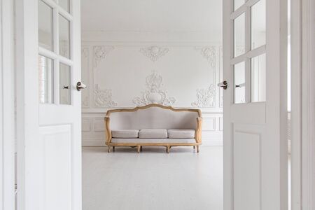 Luxurious bright Rococo interior with a large sofa and stucco on the walls. Selective focus.の写真素材
