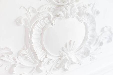 Luxury interior. Stucco elements on light wall. White patterned. Mouldings element from gypsum. Roccoco style.の写真素材