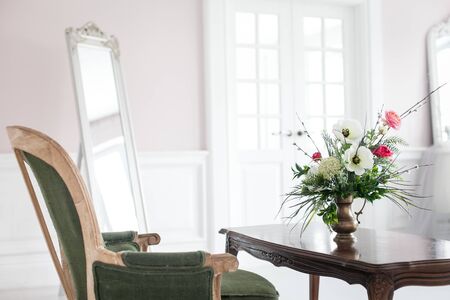 A bouquet of artificial flowers in a vase in the luxurious interior of the room. Soft focus.の写真素材