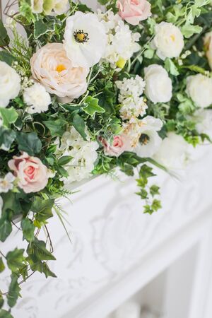 Decoration of the fireplace with flowers in a bright interior. close up. Soft focus.の写真素材