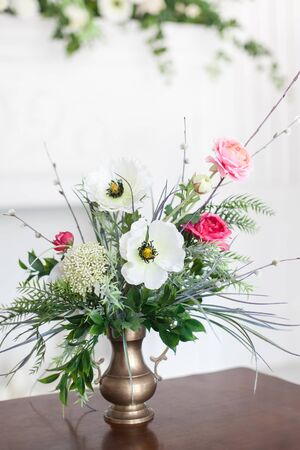 A bouquet of artificial flowers in a vase in the luxurious interior of the room. Soft focus.の写真素材