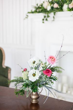 A bouquet of artificial flowers in a vase in the luxurious interior of the room. Soft focus.の写真素材