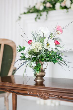 A bouquet of artificial flowers in a vase in the luxurious interior of the room. Soft focus.の写真素材