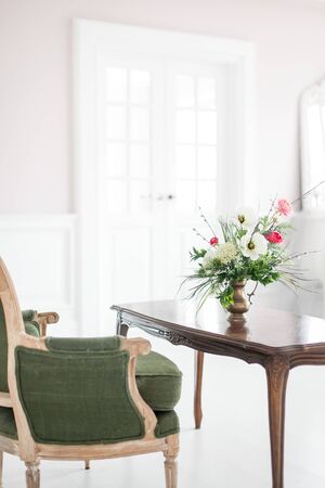 A bouquet of artificial flowers in a vase in the luxurious interior of the room. Soft focus.の写真素材