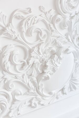 Luxury interior. Stucco elements on light wall. White patterned. Mouldings element from gypsum. Roccoco style.の写真素材