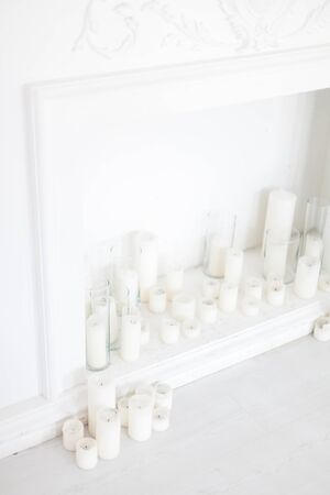 The decoration of the portal of the fireplace with candles and glass vases. Soft focus.の写真素材