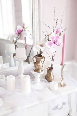 Delicate and light decoration of the dressing table with flowers, candles. Soft focus. Close up.の写真素材